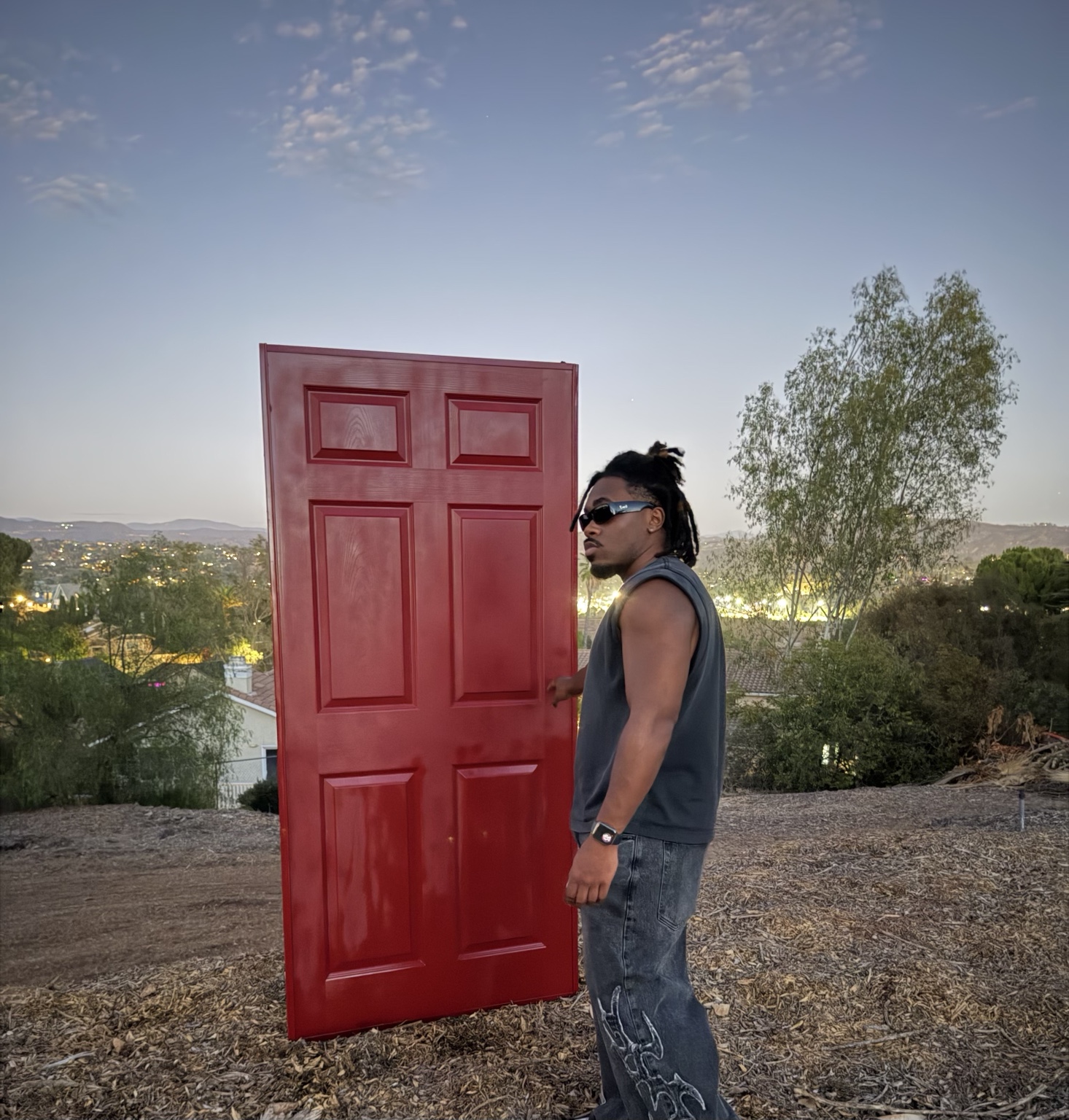 Shalant beside a red door at twilight